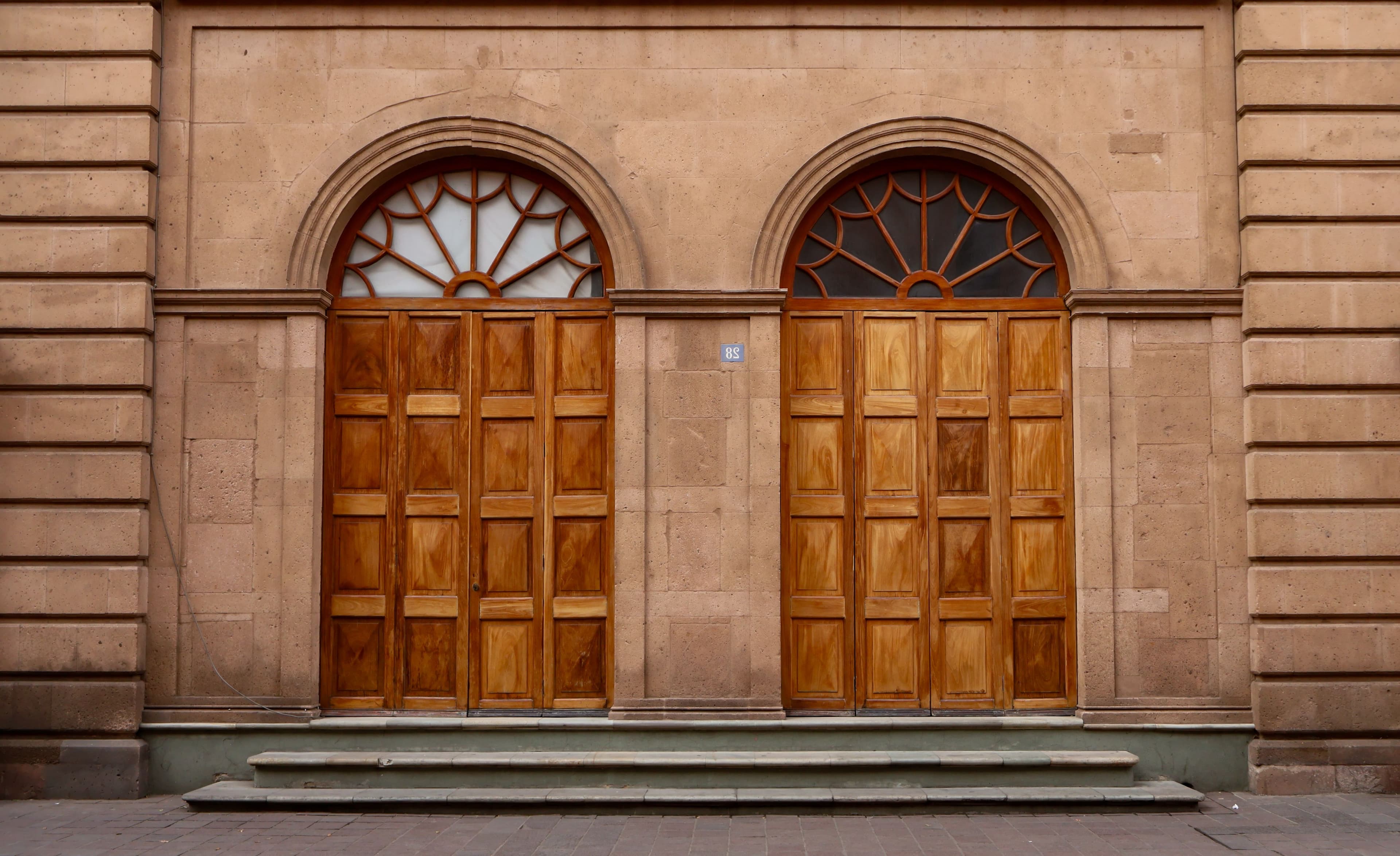 Arched wooden doors set in a warm stone facade